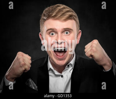 Young man cellebrate on a dark background. Stock Photo