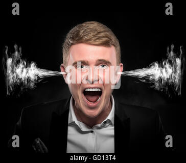 Angry man with smoke or fume coming out from his ears on dark background. Stock Photo