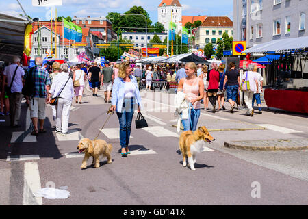 Ronneby, Sweden - July 9, 2016: Big public market day in town with lots of people. Here two women walk by with dogs in leashes w Stock Photo