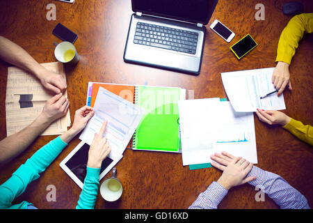 Business team hands at work with financial reports and a laptop, top view Stock Photo