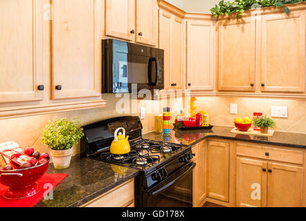 Black Appliances in Decorated Kitchen with wood cabinets Stock Photo