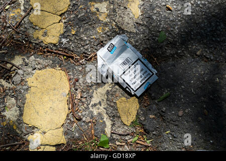 Empty packet of Lambert and Butler cigarettes discarded by yellow lines on the road Stock Photo