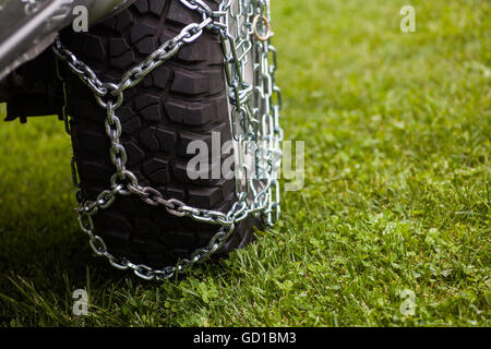 Close up shot of some chains wrapped around a car's tire. Stock Photo