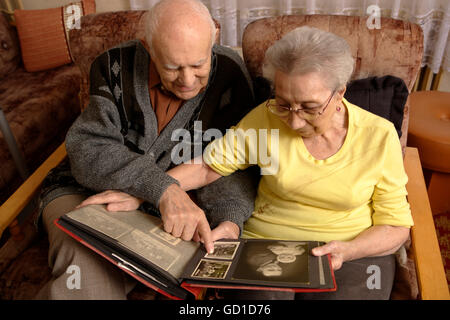 Couple of seniors, elderly man, 92, elderly woman, 89, looking into a family album Stock Photo