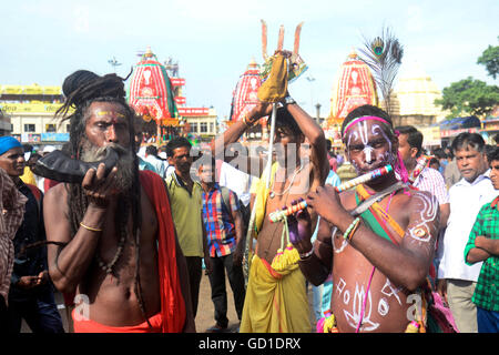 Puri, India. 06th July, 2016. Hindu holy man with the devotees dressed like God in front of the car. Krishna Devotees from all over the world gather in Puri on the occasion of Ratha Yatra festival. This is the only time in the year that devotees will see Lord Jagannath leaveing temple with vrother Balram and sister Subhadra to visit their aunt house for nine day and taken in Ratha or the car in a procession. The Ratha Yatra marks their journey from and to their Aunt house at Shri Gundicha Temple. © Saikat Paul/Pacific Press/Alamy Live News Stock Photo