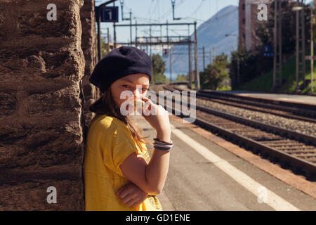 little girl waiting for the train in a deserted station Stock Photo