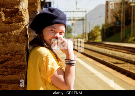 little girl waiting for the train in a deserted station Stock Photo