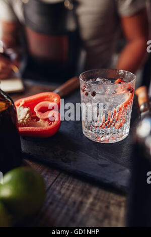 Close up of freshly prepared cocktail on bar counter with red bell pepper Stock Photo