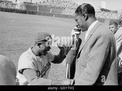 Jackie Robinson takes a moment to speak to Nat King Cole Stock Photo