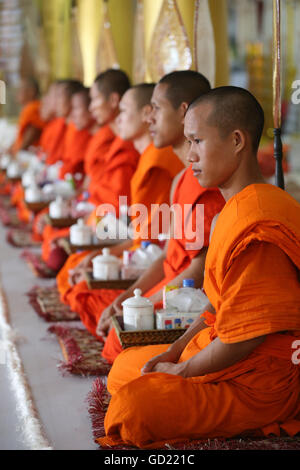 Seated Buddhist monks chanting and reading prayers at a ceremony, Wat Ong Teu Buddhist Temple, Vientiane, Laos, Indochina, Asia Stock Photo
