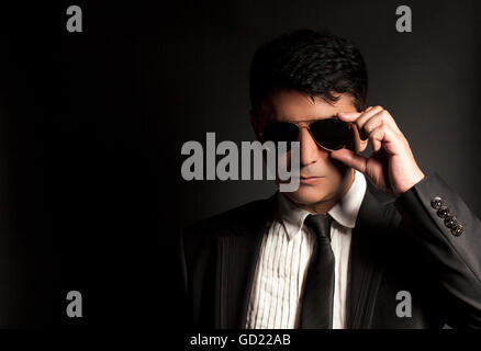 Business man in suit with sunglasses on a black background Stock Photo