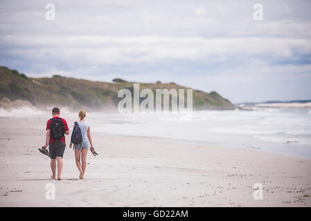 Tourists walking on Rarawa Beach, a popular and beautiful white sand beach in Northland Region, North Island, New Zealand Stock Photo