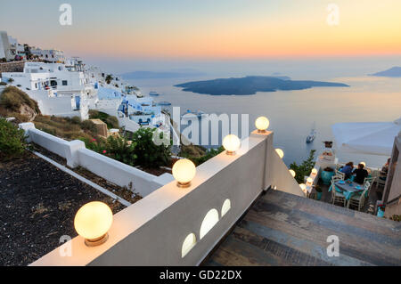 The fiery red sky on the Aegean Sea after sunset seen from the typical terraces of Firostefani, Santorini, Cyclades, Greece Stock Photo