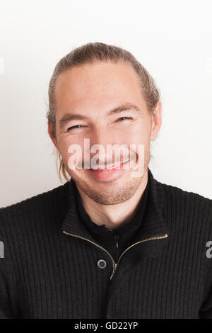 Closeup studio portrait of smiling young adult Asian man above white background Stock Photo