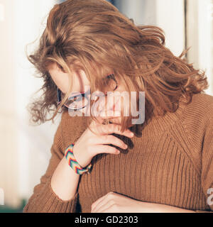 Beautiful blond teenage girl  in glasses and warm sweater, closeup outdoor portrait Stock Photo