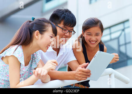 happy young asian or Chinese people using tablet outdoor Stock Photo
