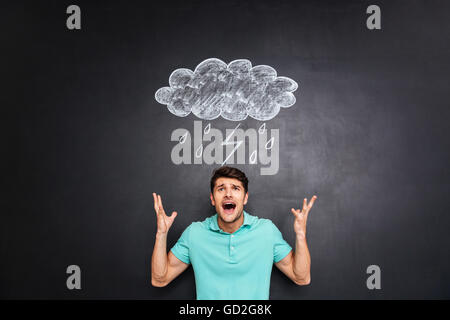 Furious young handsome man yelling over background of chalkboard Stock Photo