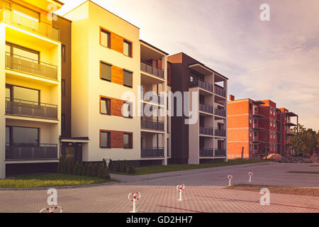 New multi-family block with balconies and bright facade decorated with wood paneling. Stock Photo