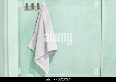 White towel hanging on a wall in bathroom. Stock Photo