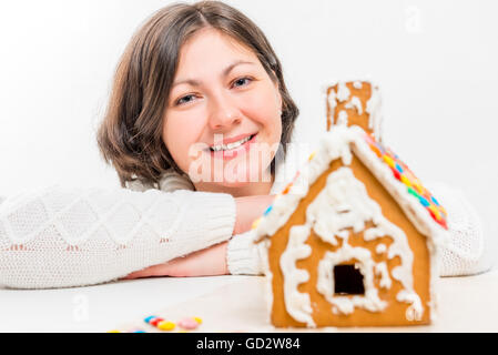 beautiful woman and a gingerbread house handmade Stock Photo