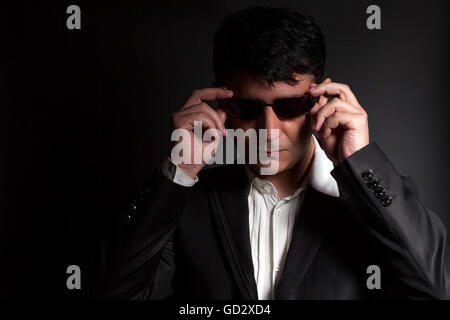 Business man in suit with sunglasses on a black background Stock Photo