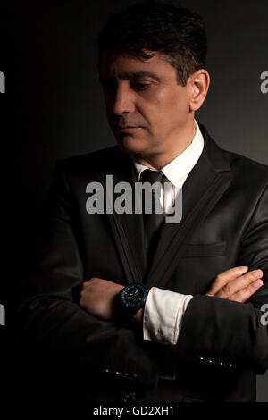 Business man in black suit with tie on a black background Stock Photo