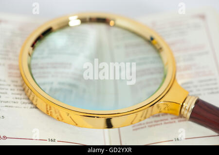 Open book with magnifying glass over white background Stock Photo