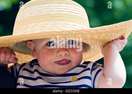 Baby boy wearing a straw sun hat Stock Photo