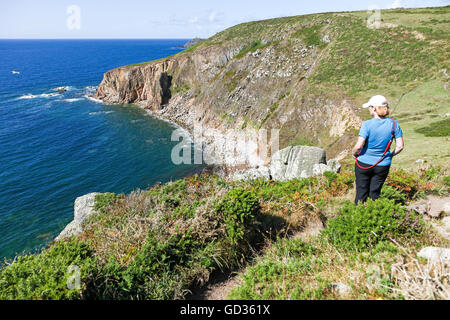 A woman looking out to sea at Tregiffian Vean cliff near to Sennen Cove Cornwall England UK Stock Photo