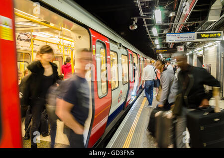 Passengers disembark and board a London Underground train at Victoria Station. Stock Photo