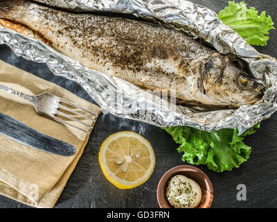 Grilled sea bass fish on the gray table. Stock Photo