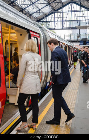 People board a London Underground train at Earl's Court in London. Stock Photo