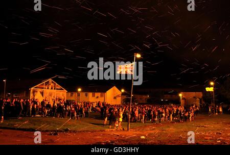 Crowds watch as a huge bonfire on the Shankill Road in Belfast is lit on the &quot;Eleventh night&quot; to usher in the Twelfth commemorations. Stock Photo