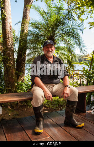 Man wearing rubber boots getting ready to go for a hike in the tropical jungle around the Pachira Lodge in Tortuguero Stock Photo