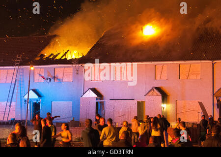 Belfast, Northern Ireland. 11 Jul 2016 - A fire takes hold on the roof of a second house, after the traditional '11th Night' bonfire was lit in the Lower Shankill Estate. Credit:  Stephen Barnes/Alamy Live News