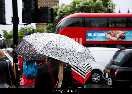 London, UK. 12th July, 2016. UK Weather: Torrential downpour in Westminster. A bus with an advert 'Hello Summer' pass by during torrential downpour  Westminster Credit:  Dinendra Haria/Alamy Live News Stock Photo