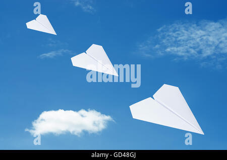 Paper plane flying over clouds with blue sky. Stock Photo