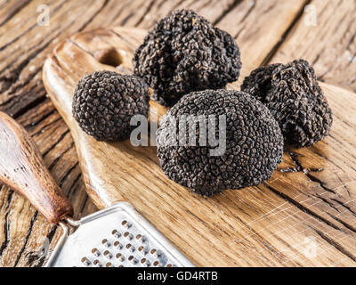 Black truffles on the old wooden table. Stock Photo