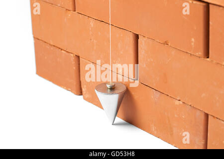 Mason checking plumb line of house wall being made from aerated