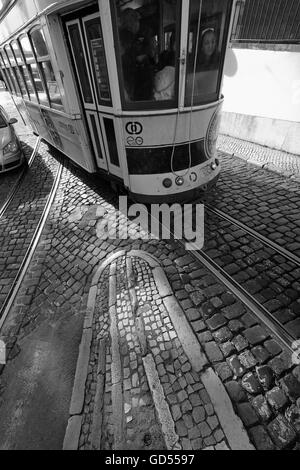 Trams Lisbon with sunlight casting patterns and shadows on the cobbles and tram tracks