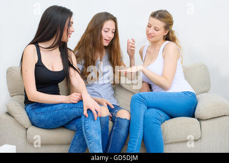 Portrait of three happy pretty young women at home Stock Photo