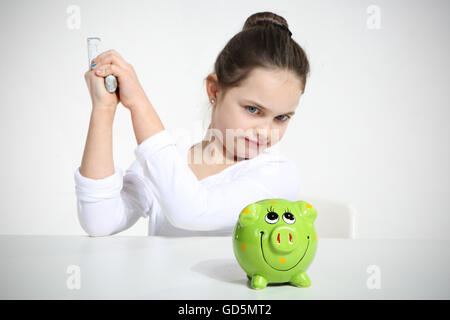 Little girl breaking piggy bank isolated on white Stock Photo
