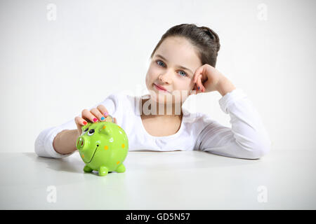 Portrait of little girl with piggy bank isolated on white Stock Photo