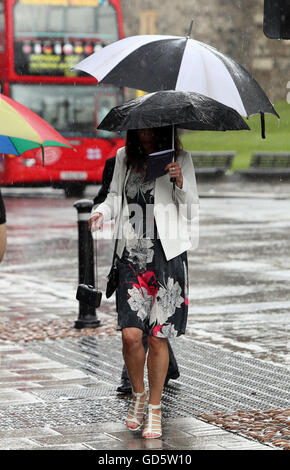 An Investiture guest braves a rain shower in Windsor, Berkshire. Stock Photo