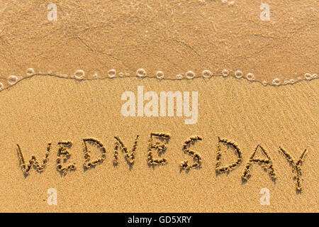 Wednesday - hand-written on the sand in line of the sea surf.