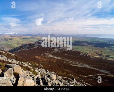 View east from the summit of Yr Eifl over Tre'r Ceiri Iron Age hillfort towards the snow capped mountains of Snowdonia, Lleyn, North Wales, UK Stock Photo