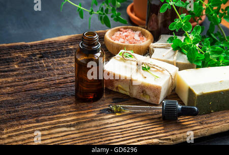 Herbal spa therapy with body oil, natural soap, salt and green herb Stock Photo