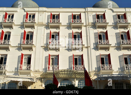 Old white hotel building with red window shutters Stock Photo