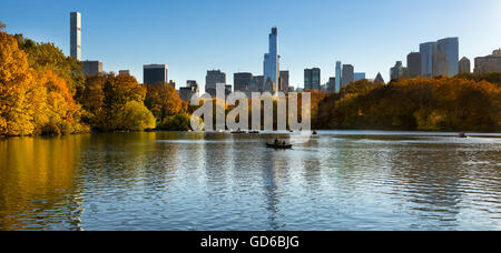 Fall in Central Park at The Lake with Midtown Manhattan skyscrapers. Panoramic  cityscape with colorful fall foliage in New York Stock Photo