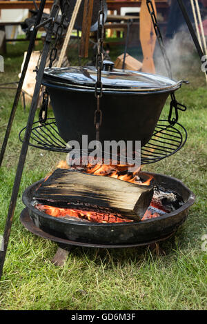 Big cooking pot placed on fire in a camping outdoors. Stock Photo